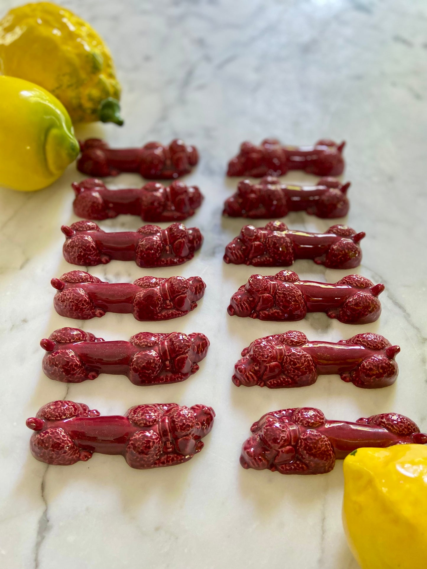 12 porte-couteaux "Dog" en céramique bordeaux - 1950.